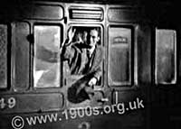 Waving goodbye through an open train window in the 1940s