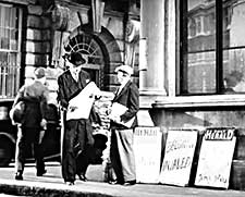 Newsvendor selling newspapers in the street