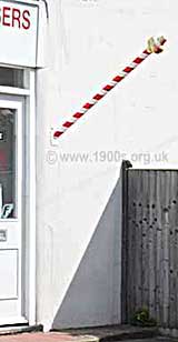 Red and white striped pole signifying a barber's shop, both now and in the 1900s