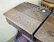 Child's school desk, common in Victorian times to the 1960s, with the lid down to serve as a writing surface. Note the indent along the top, by the inkwell for pens and pencils