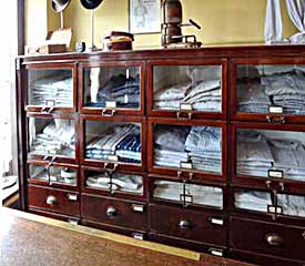 More typical dark wood and glass display units as seen inside drapers shops in the early to mid 1900s