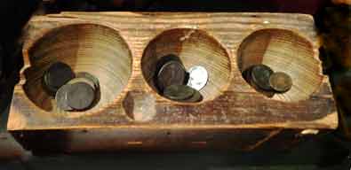 Old shop till: large block of wood with hollows dug out for different coins